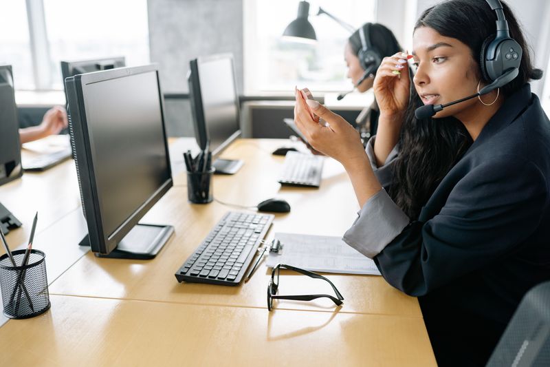 A woman wearing a headset working at a computer